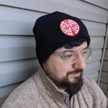 Man wearing a Catholic beanie or hat with a Saint Benedict medal stitched onto it.