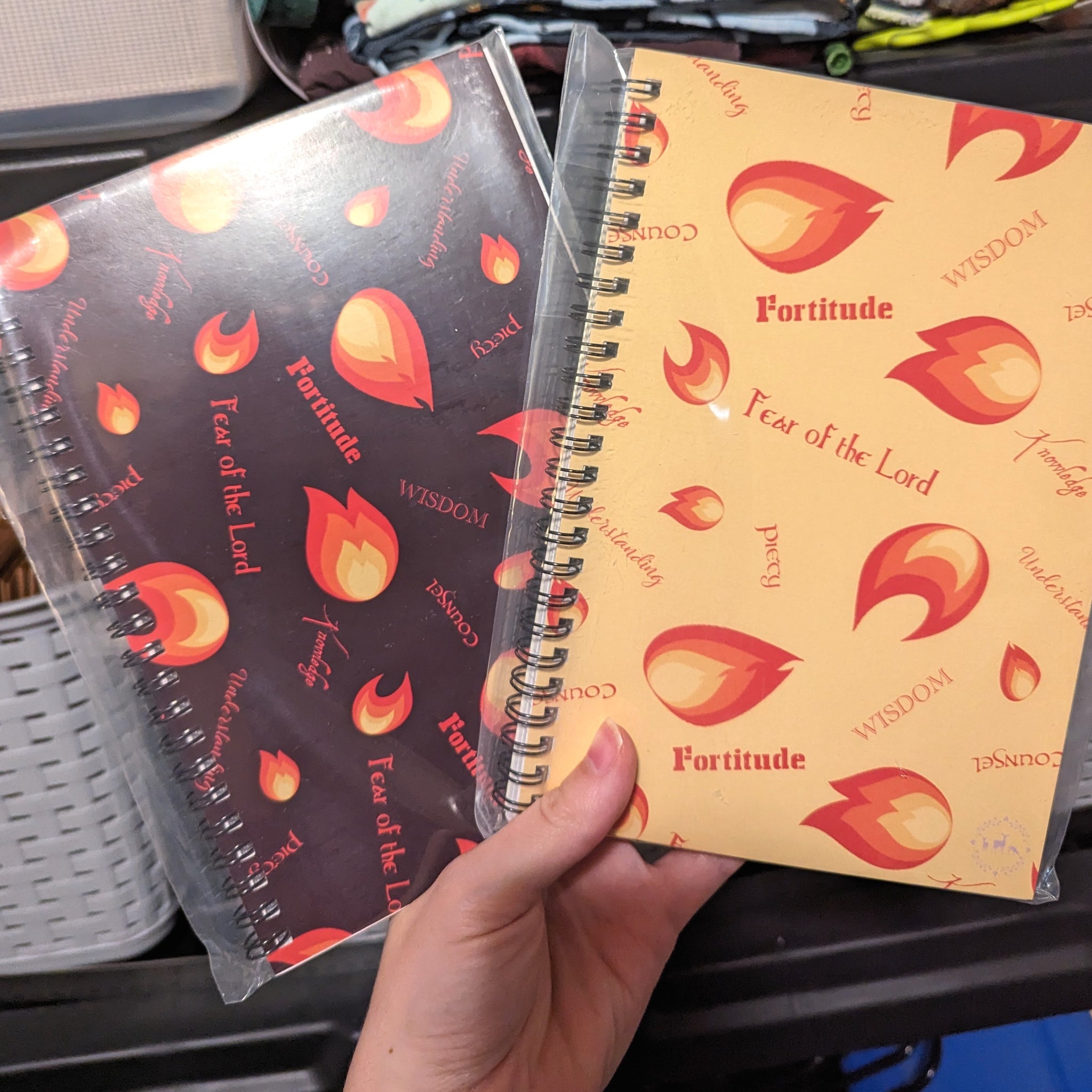 Two spiral notebooks, or journals, featuring a flame design and the Gifts of the Holy Spirit.